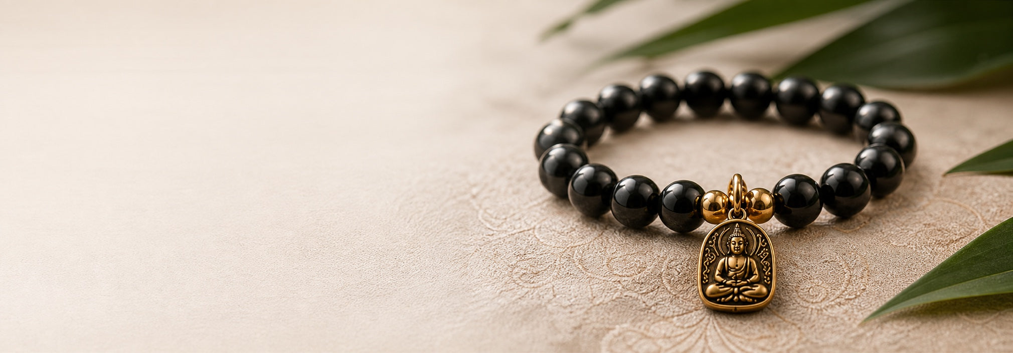 Black obsidian bracelet with a gold Buddha pendant