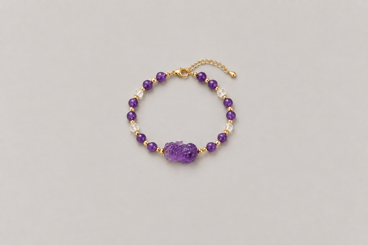 A complete purple-toned bracelet with a side-profile carved animal-like centerpiece facing left, a clasp, and an extension chain on a warm gray background