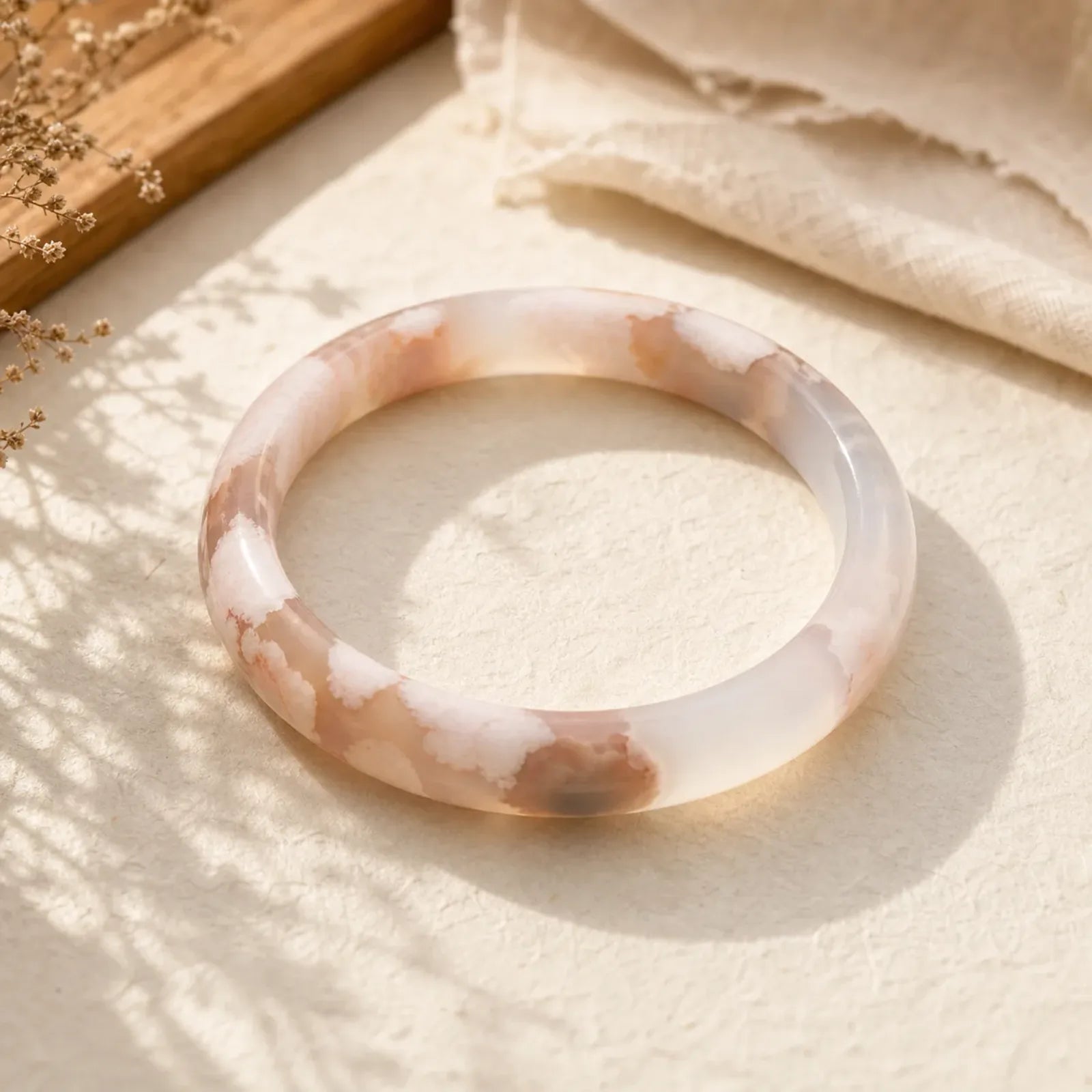 Handcrafted agate bangle with natural white and peach patterns, ideal for healing and protection